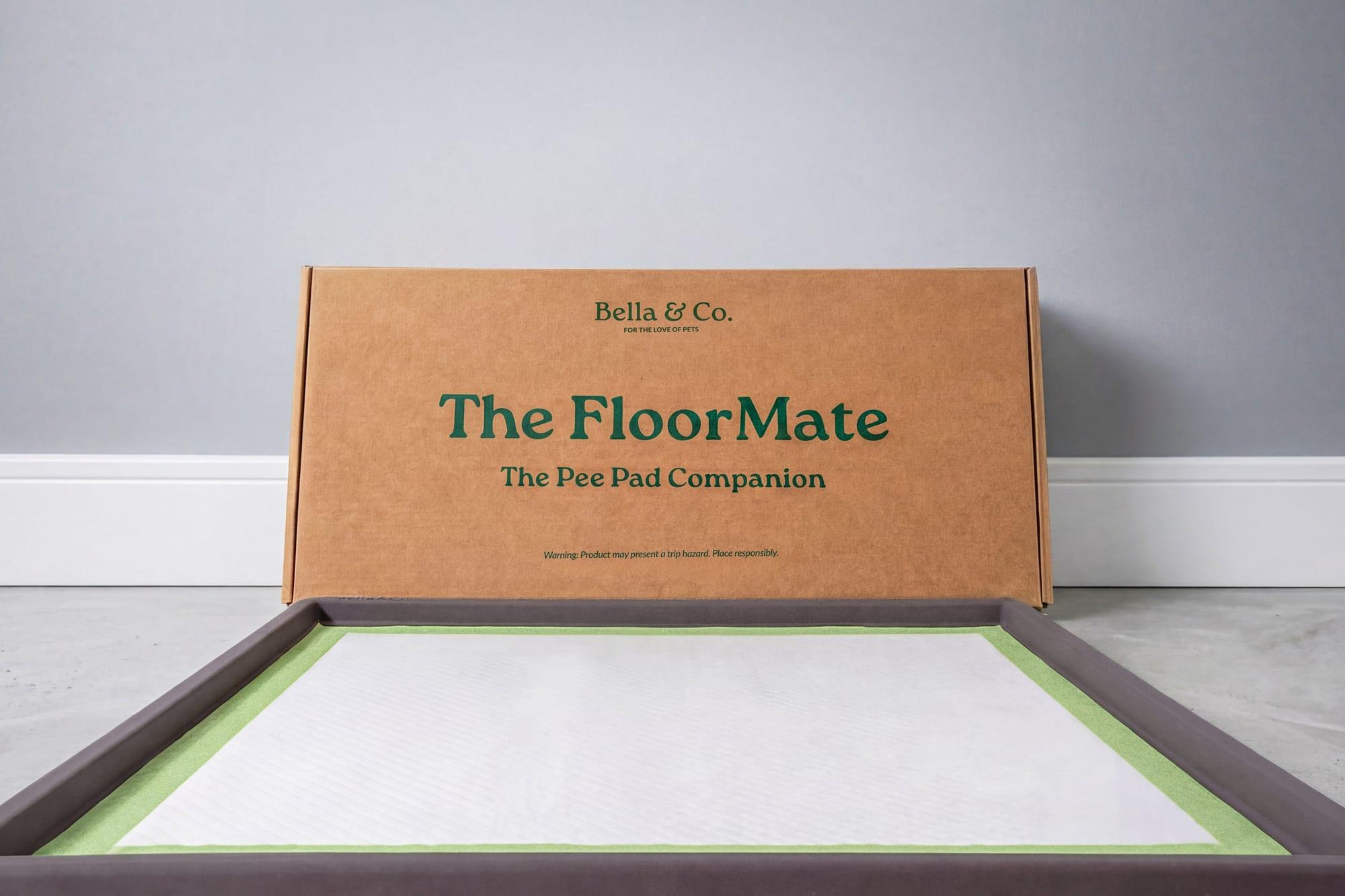 The FloorMate with a Pee Pad loaded, next to its packaging